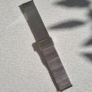 En stållänk i meshdesign i silverfärg med spänne på mitten