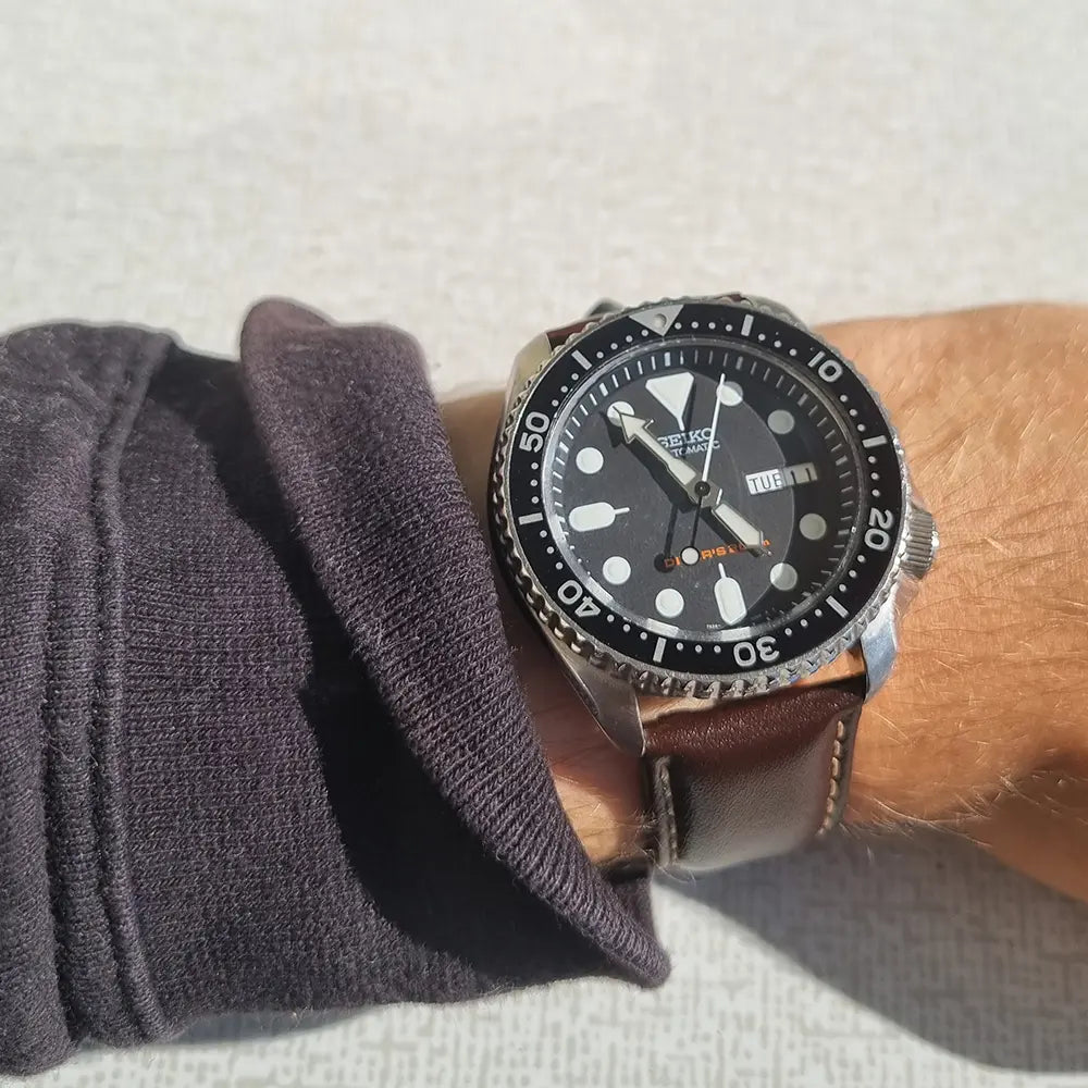 En SEIKO SKX007 med mörkbrunt klockband på handleden