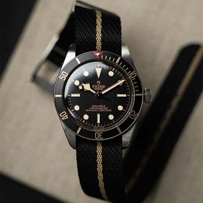 En Tudor Black Bay 58 med ett svart klockarmband av nylon med ett grönt streck på mitten