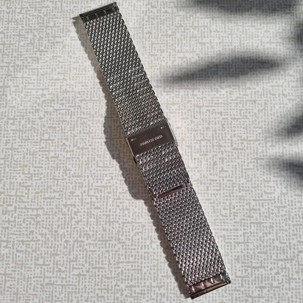 Baksidan av ett silvrigt mesh klockarmband
